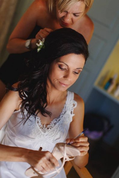 Bride preparation, bridal hairstyle with loose beach waves and white flowers.