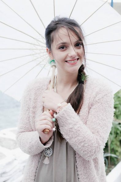 Beautiful smiling girl holding an umbrella for the sun.