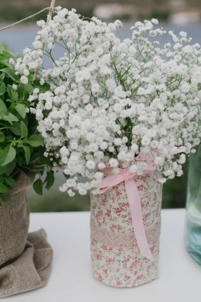 Romantic fabric wrapped vase with white flowers and a pot of basil.