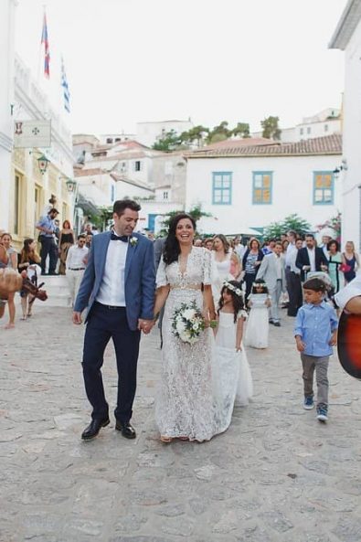 Bride, groom and bridal parade walking to church with traditional Greek music on a Greek island.