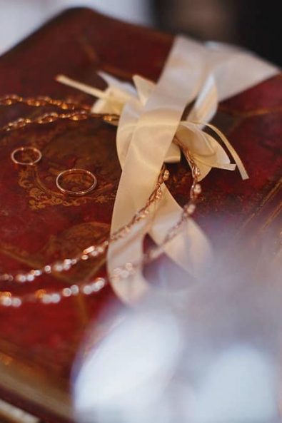 Rose gold wedding crowns with pearls and white silk joining ribbon and rose gold wedding rings for a greek orthodox destination wedding.