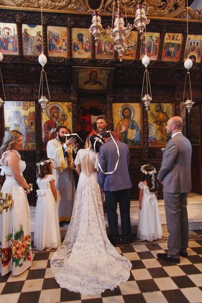 Bride and groom standing next to each other in the church for a Greek Orthodox destination wedding in Greece.