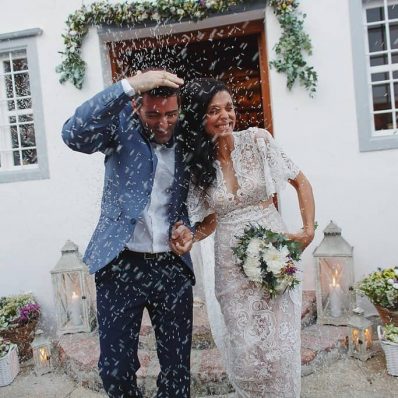 Bride and groom getting showered with rice.