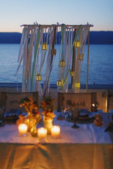 Hanging lantern decorations with candles, flowers, and ribbons.