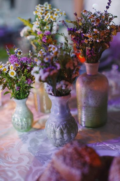 Marble flower vases with wildflowers for a summer wedding.