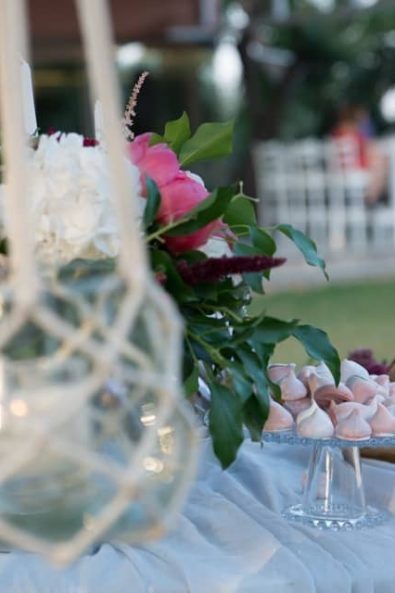 Wedding flowers and meringue french dessert on a candy bar.