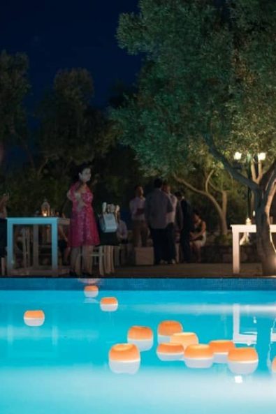 Wedding venue in the nighttime with a pool and floating lanterns looking like a dream.