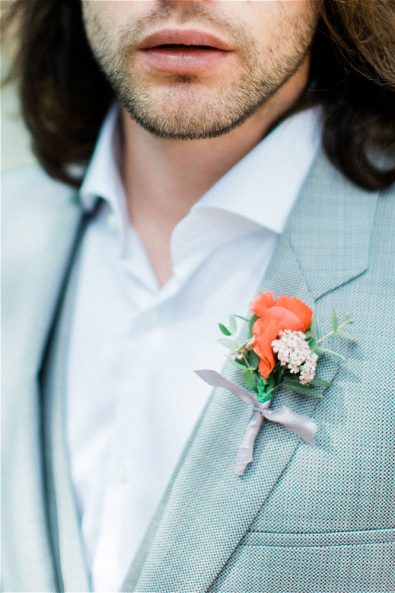 Red boutonniere on groom