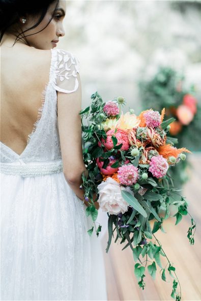 Back photo of bride holding wedding bouquet