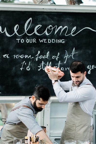 Barmen serving guests drinks from van