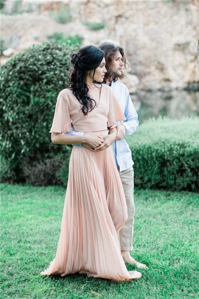 Groom hugs bride around the waist at Late Vouliagmeni