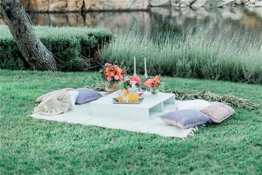 Picninc with pillows, flowers and candles setup for an elopement in Greece