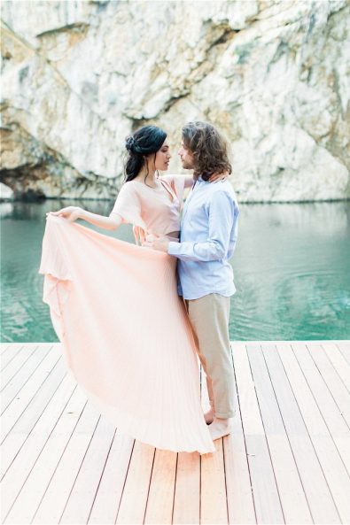 Groom holding bride in front of Lake Vouliagmeni at their elopement in Greece