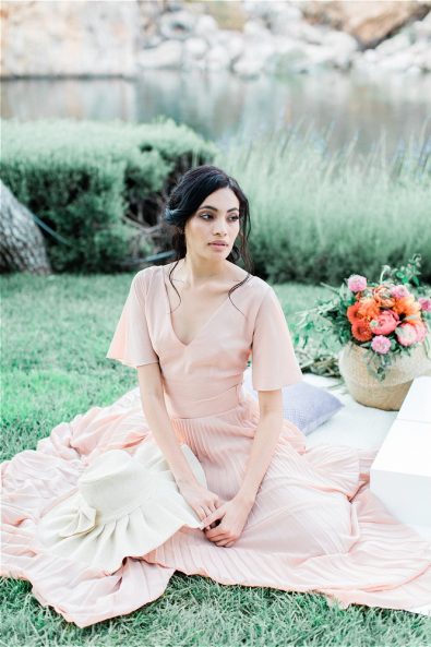 Bride sitting on picnic clot at her elopement in Greece