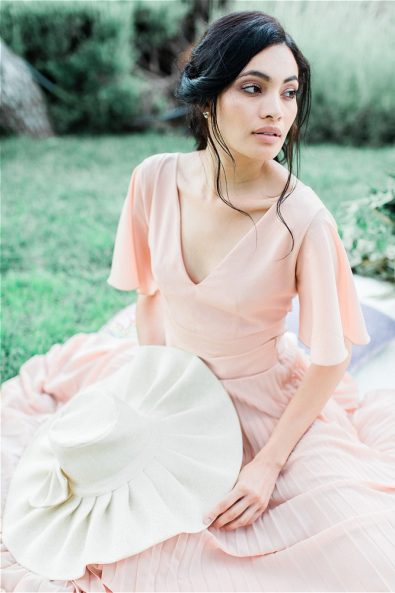 Bride sitting down on picnic clot at her elopement in Greece