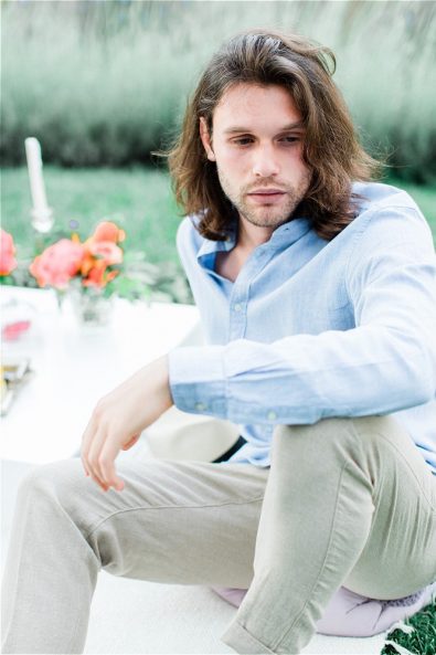 Groom sitting on pillow at Late Vouliagmeni