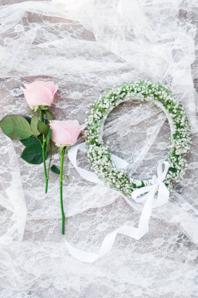 Christening - White baby's breath flowers flower crown on white lace with two pink roses.