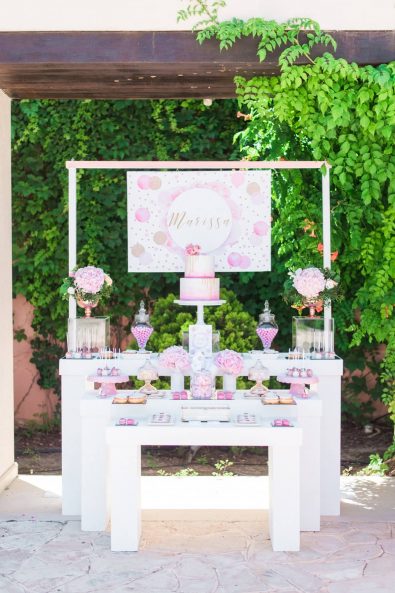 Candy bar dessert stand for a destination baby christening baptism in Leukada, Greece with pink and rose gold details and sweet treats, macarons, cake pops, donuts and chocolate crispies.