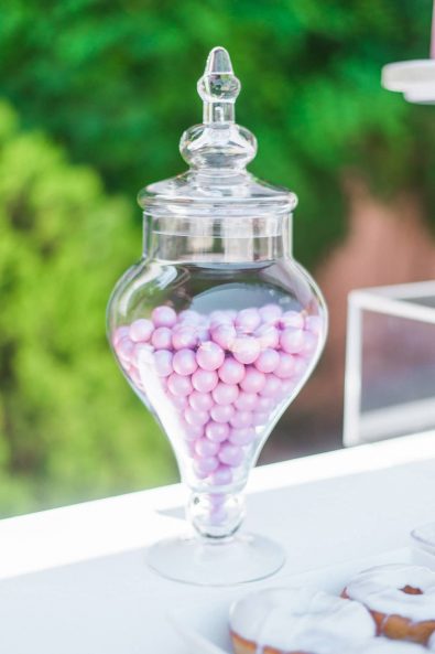 Glass candy jar with pink chocolate crispies koufeta for a baptism candy bar.