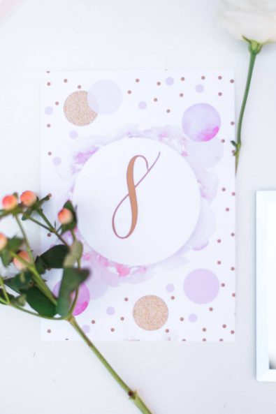 Close up shot of pastel pink and lilac purple confetti table number card for a baby christening.