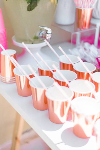 Close up shot of copper party paper cups lined in a straight line for a refreshments stand at a baby christening.