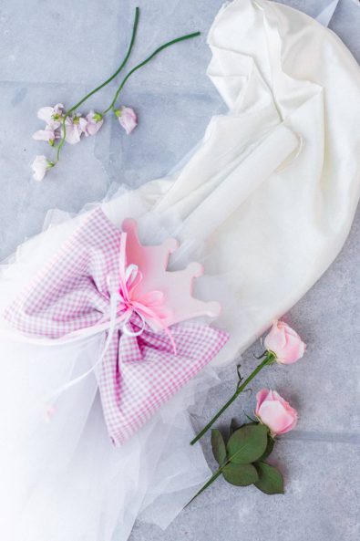 Christening candle lampada with white tulle and pink bow with a crown wooden decoration for a baby christening.