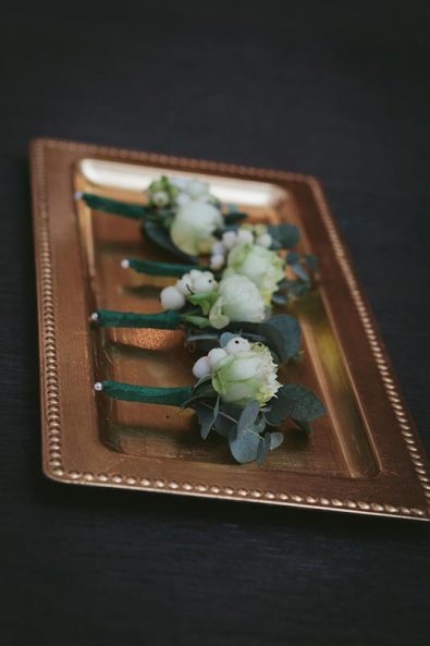 Organic and minimal wedding flower boutonniere with eucalyptus leaves, roses, and hypericum berries.