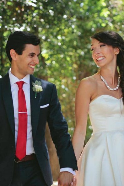 Bride and groom holding hands and looking at each other in the National Garden of Greece after their jewish wedding in Athens.