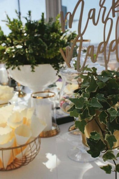 Wedding candy bar with a vines flower arrangement.
