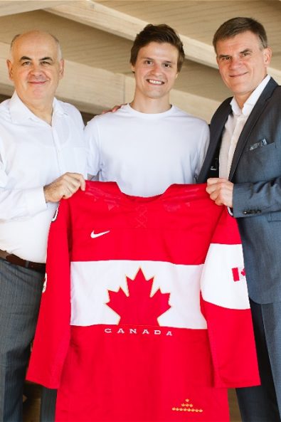three men holding a canadian t-shirt