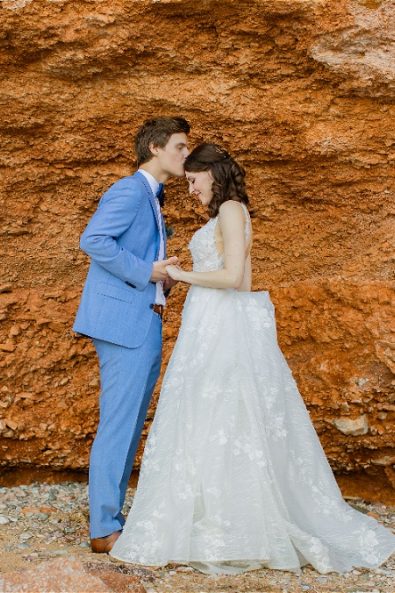 Groom kissing bride on forehead