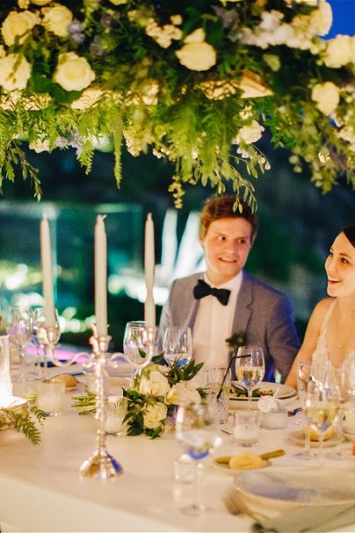 Bride and groom sitting with their families