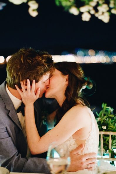 bride and groom kissing at their wedding table