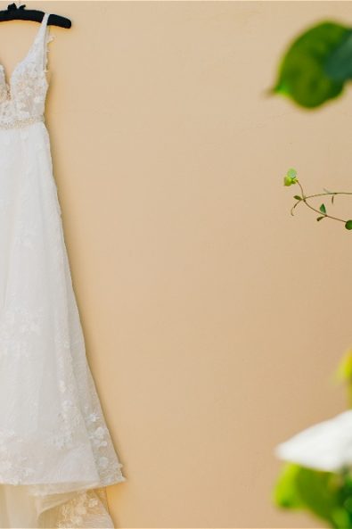 Wedding dress hanging on pink wwall