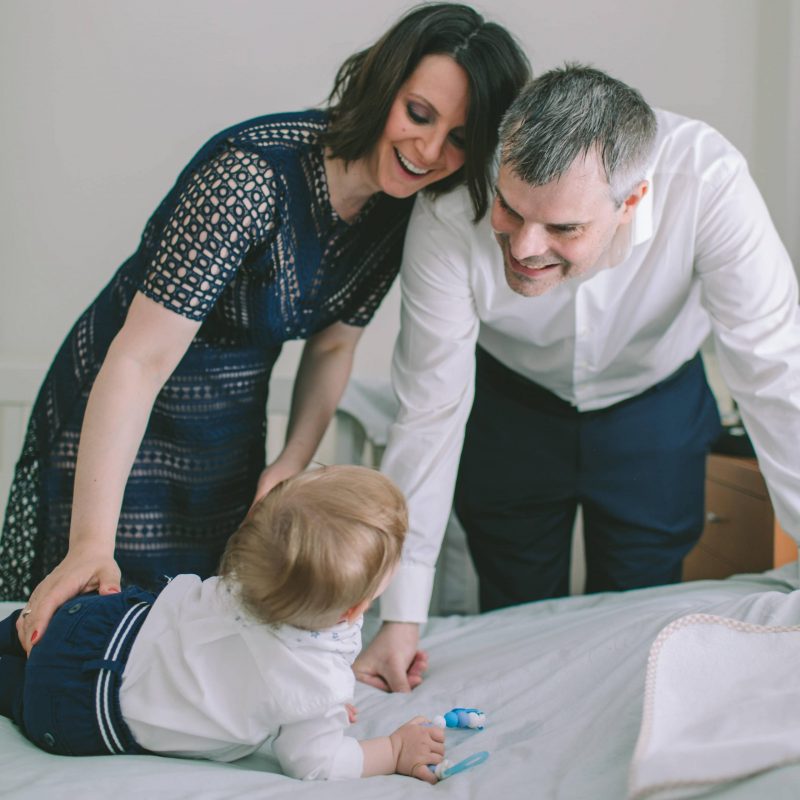 Sweet parents smiling to their baby boy on his baptism day before his amazing event.