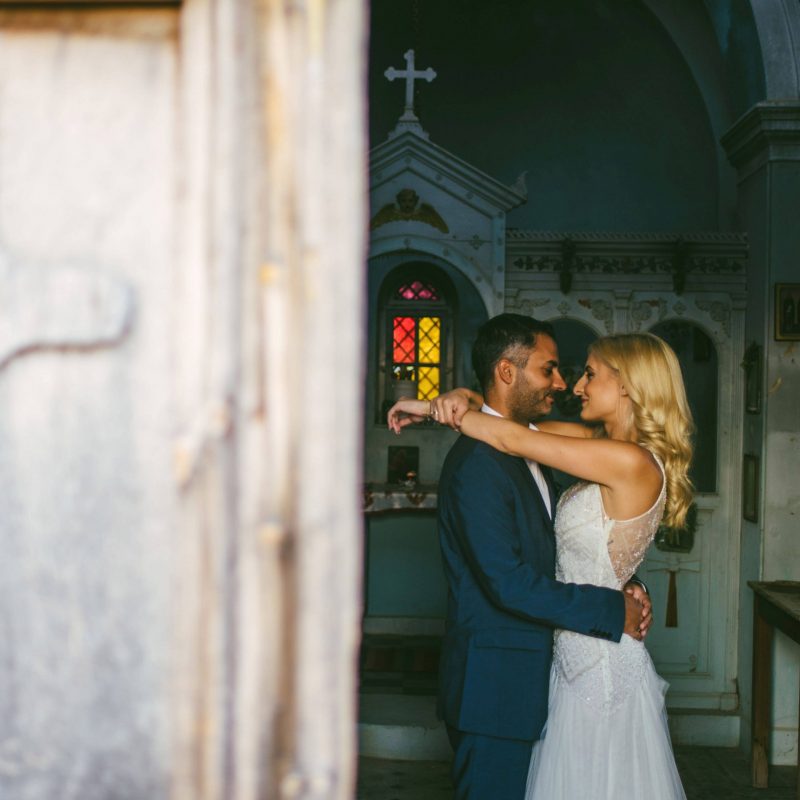 White stories events wedding: Couple in love bride and groom looking at each others eyes hugging in a church after their wedding.