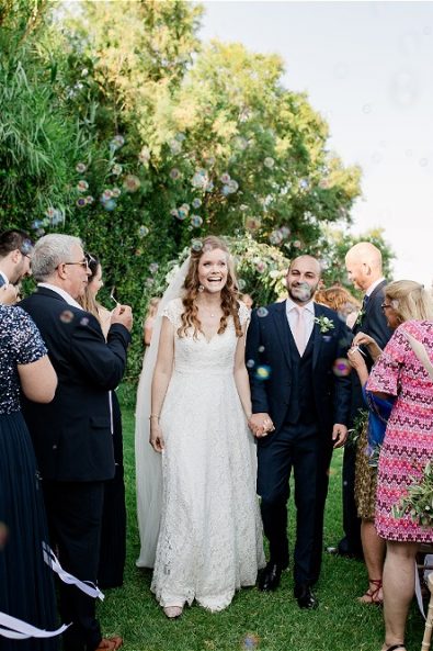 Rice being thrown on couple on garden aisle