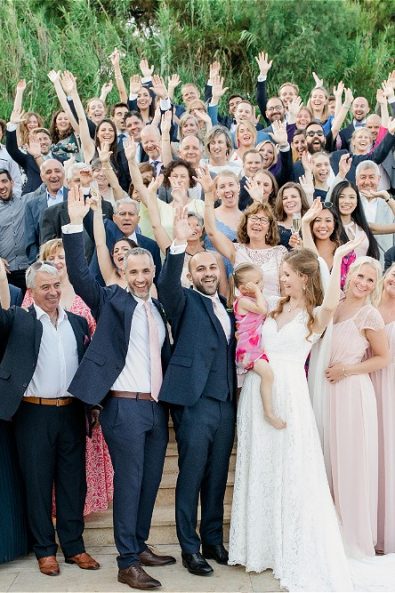 Couple with guests waving at camera