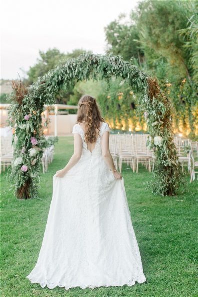 Bride walking towards wedding arch