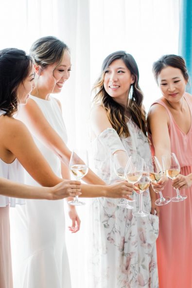 The bride and her friends drinking wine before the wedding.
