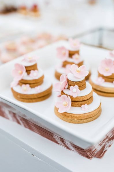 Biscuit cakes with sugar paste and pink roses made of fondant.