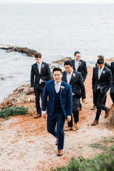 Groom and groomsmen walking on the beach before the wedding.