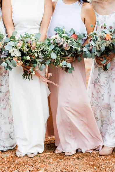Close up shot of bride's and bridesmaids' flower bouquets and dresses.