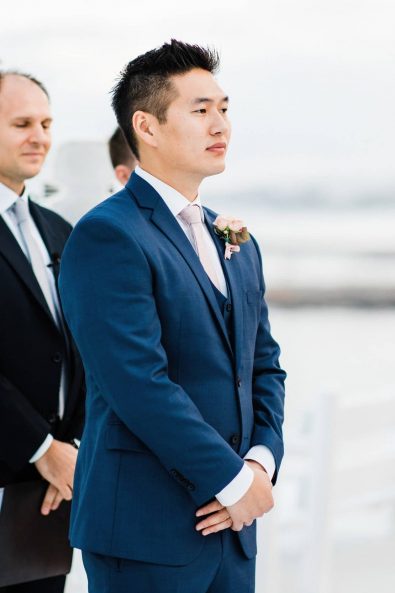 Korean Groom waiting for his bride at the wedding arch.