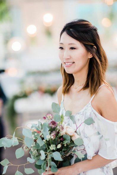 Bridesmaid holding her flowers walking down the aisle.