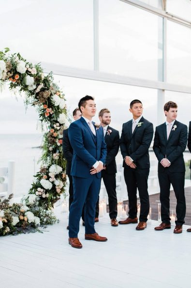 The groom waiting for his bride at the altar while she walks toward him.