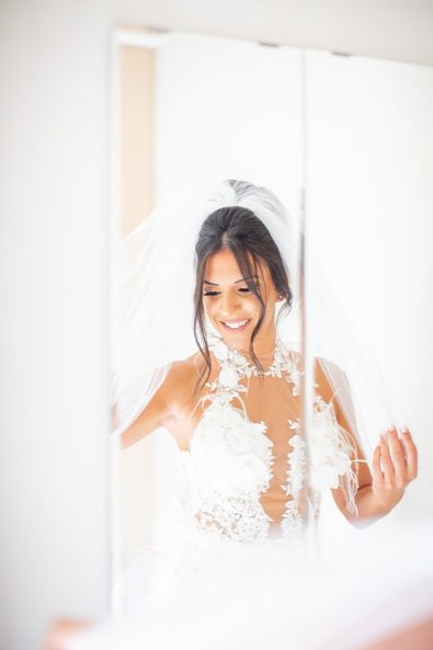 Bridal portrait pose with the bride wearing her veil and lace wedding dress.