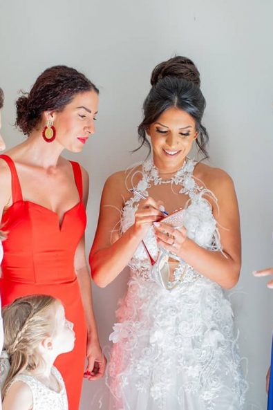The bridal squad and the bride while she writes her single friends' names under her wedding shoes.