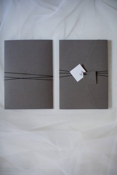Moody grey wedding invitations with black string.