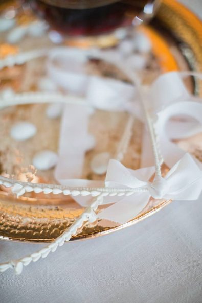 Close up shot of vintage white wedding crowns on a gold tray for a Greek Orthodox wedding.